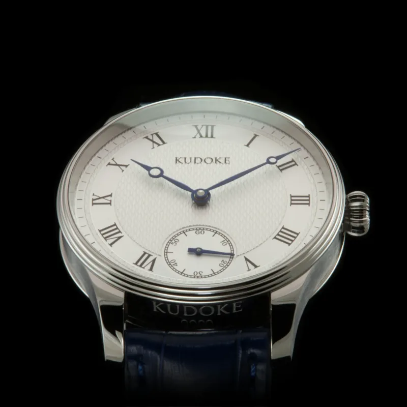 Kudoke Classic front view Kudoke Classic front view with white guilloche dial, small seconds, and tempered blue Breguet hands