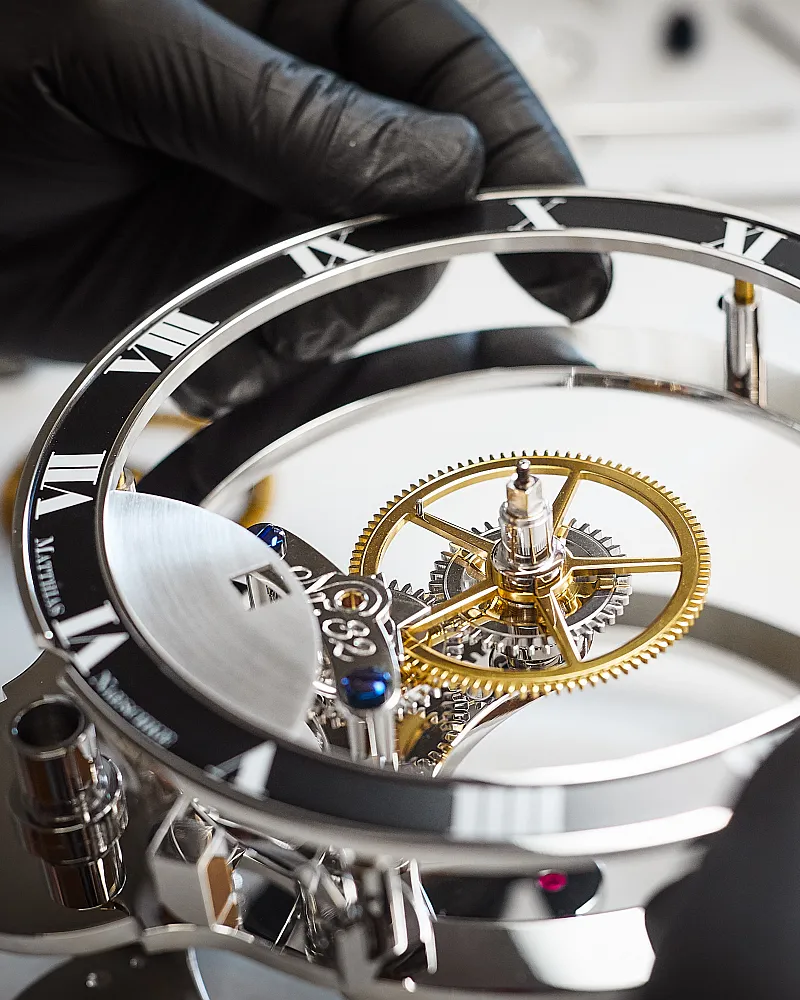 Skeleton mechanical clock movement with Roman numeral chapter ring and exposed gear assembly