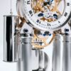 Detailed view of mechanical movement with polished weights, bridges, and intricate gear assembly of luxury table clock