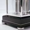 Glass canopy base with high-gloss black finish, metal inlays, and precision-crafted support feet
