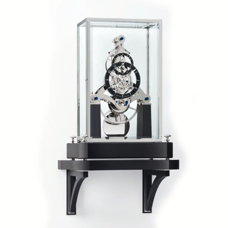 Matthias Naeschke NT 7 Table Clock displayed on wall-mounted bracket with glass canopy and visible mechanical movement